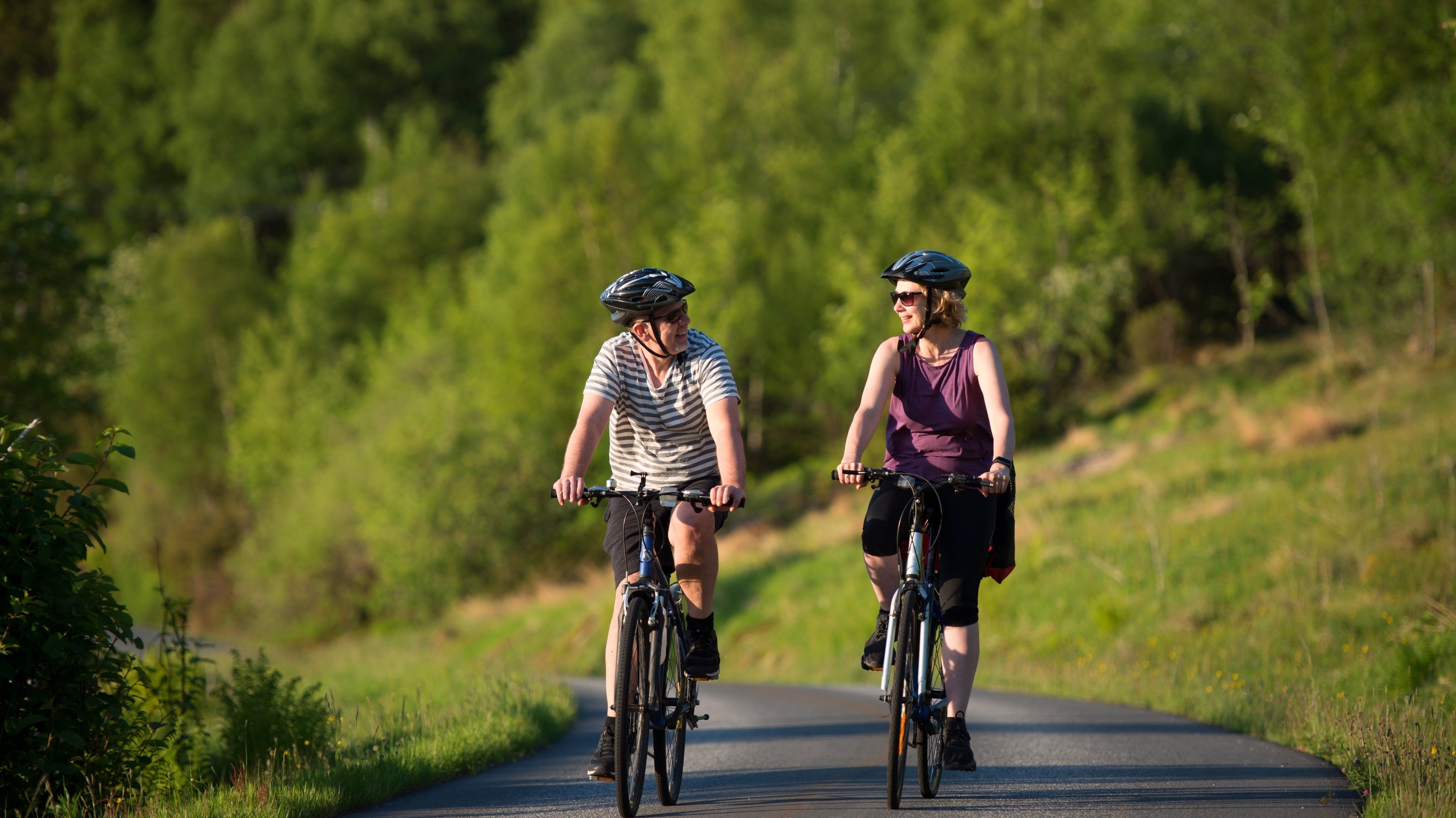 happy-couple-riding-bicycles-road