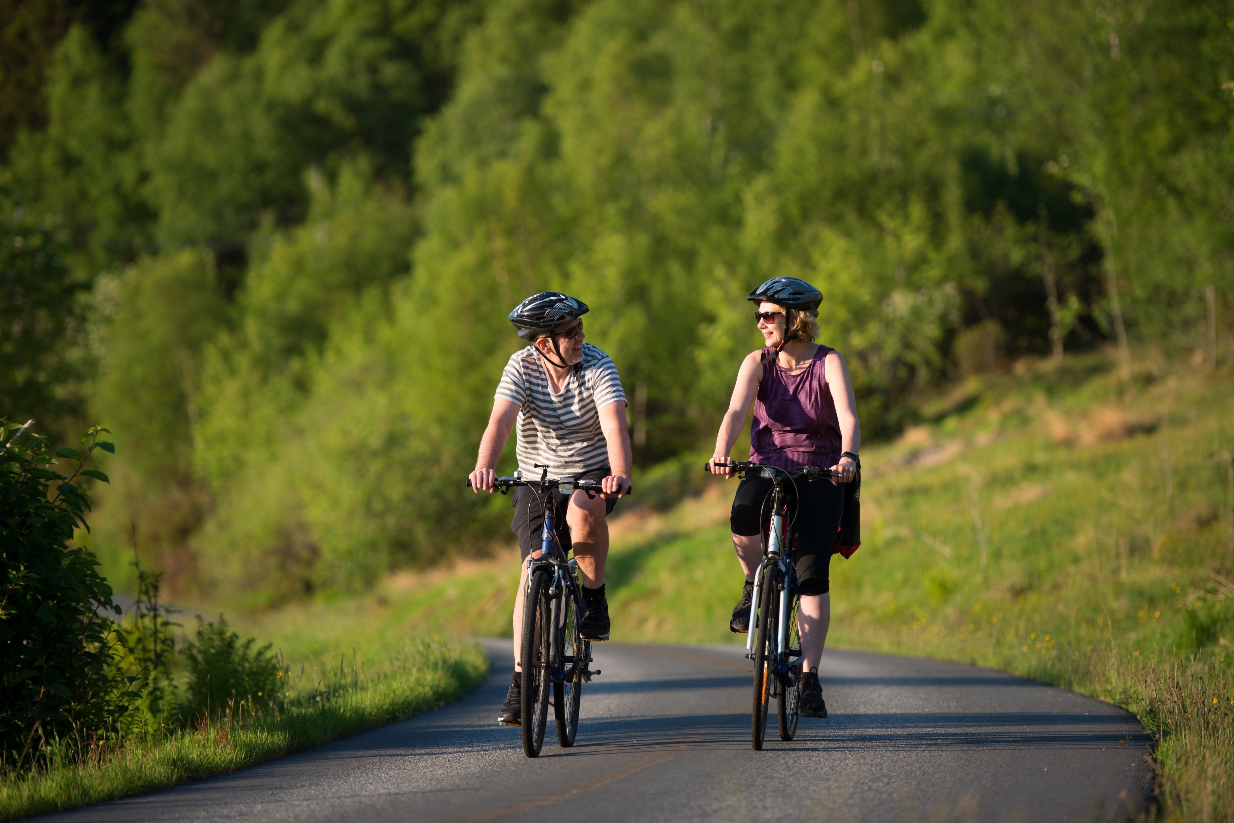 happy-couple-riding-bicycles-road